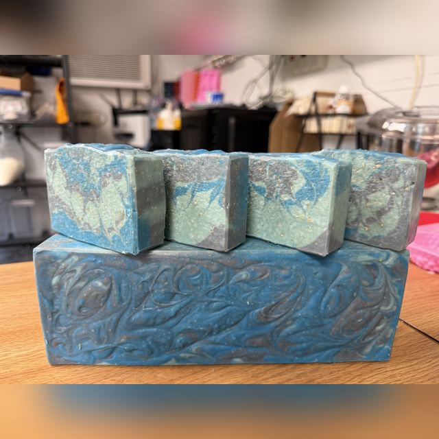 Original phone photo of Kraken soap bars stacked on a loaf on a workbench